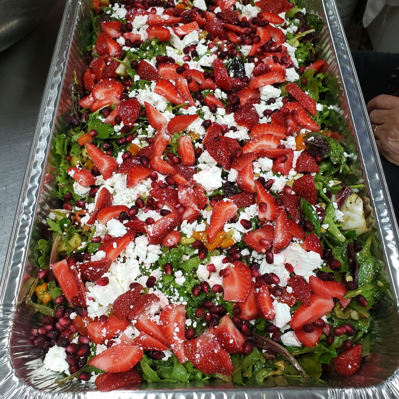 Catering tray topped with tomato and feta